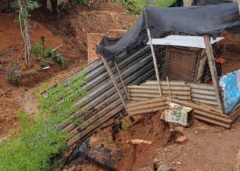 Morador é orientado a deixar casa após deslizamento de terra no bairro Vila Maria, em Formiga