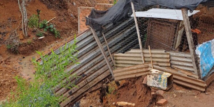 Morador é orientado a deixar casa após deslizamento de terra no bairro Vila Maria, em Formiga