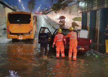 Micro-ônibus com 12 pessoas e carro ficam imobilizados em alagamento na avenida Governador Valadares em Arcos